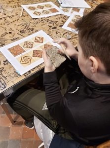 Student molding a clay tile